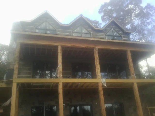 Dormers and porch framing on a large log home under construction — Roof Coating work by our crew in Port Carbon