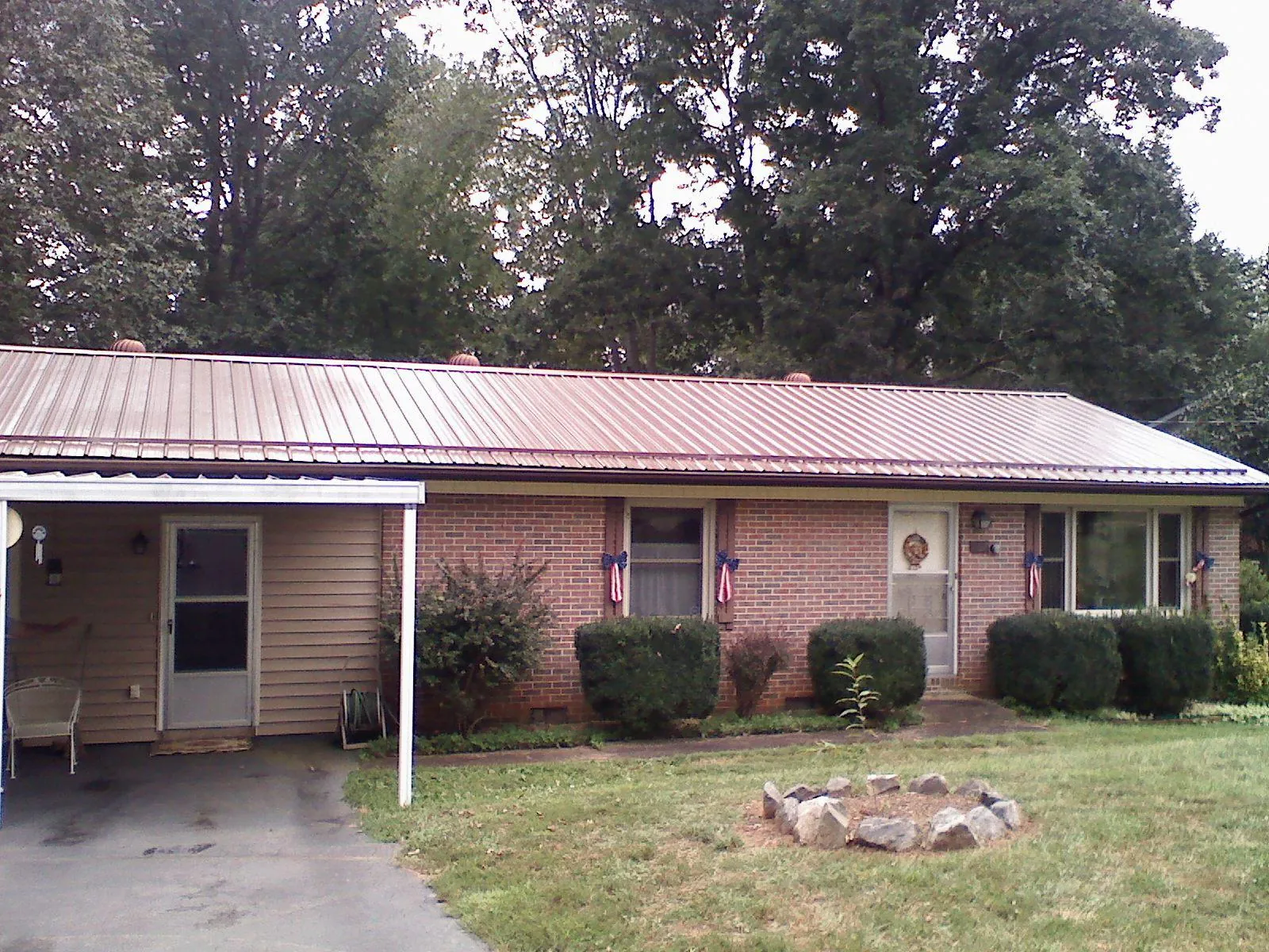 Bronze metal roof and carport on a brick ranch home — Roof Repair work by our crew in Port Carbon